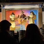Tico e Teco no palco com cowboy tocando violão no Chip n Dale Campfire do Fort Wilderness