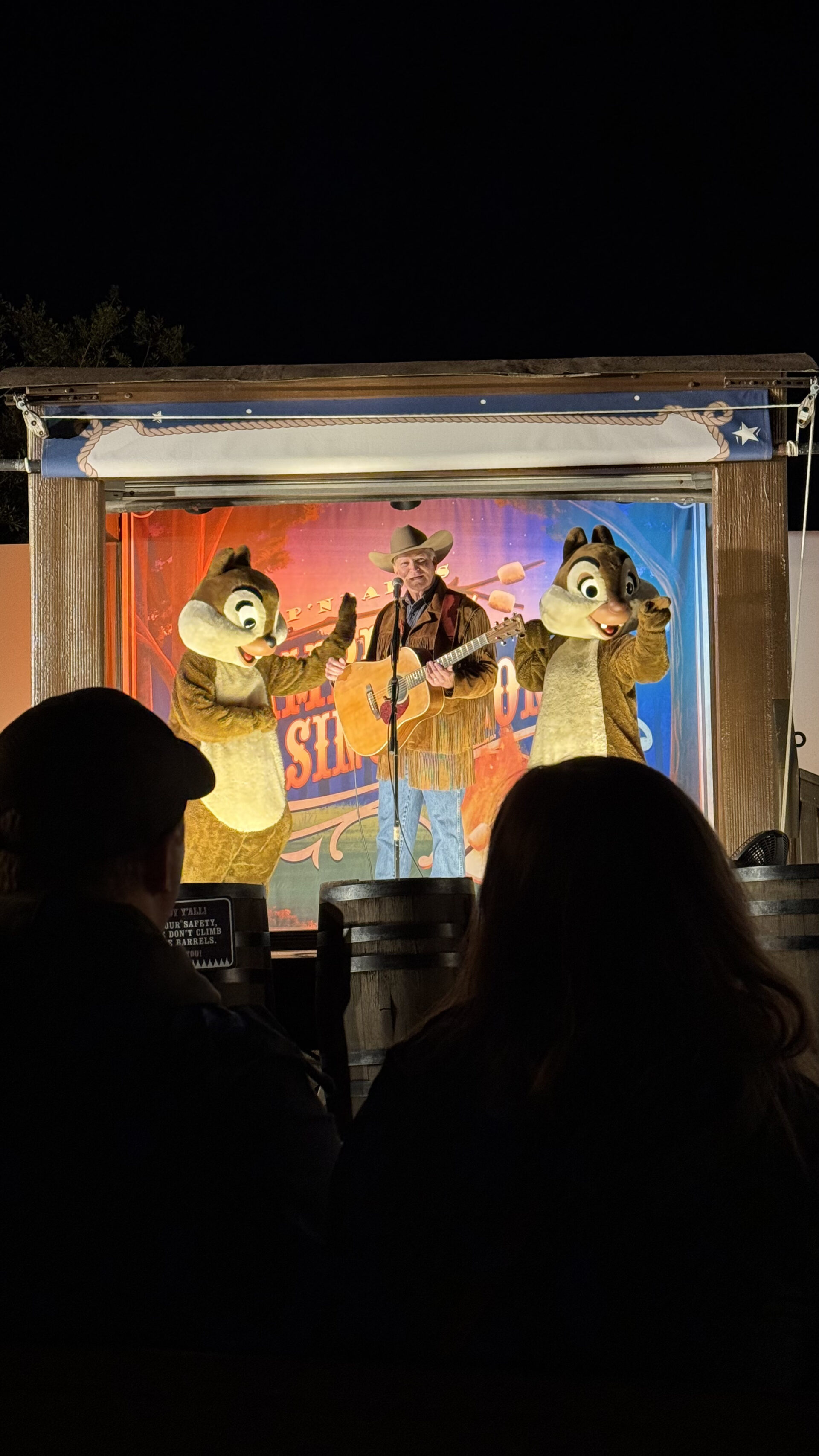 Tico e Teco no palco com cowboy tocando violão no Chip n Dale Campfire do Fort Wilderness