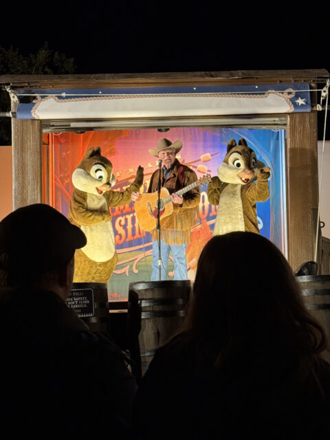 Tico e Teco no palco com cowboy tocando violão no Chip n Dale Campfire do Fort Wilderness