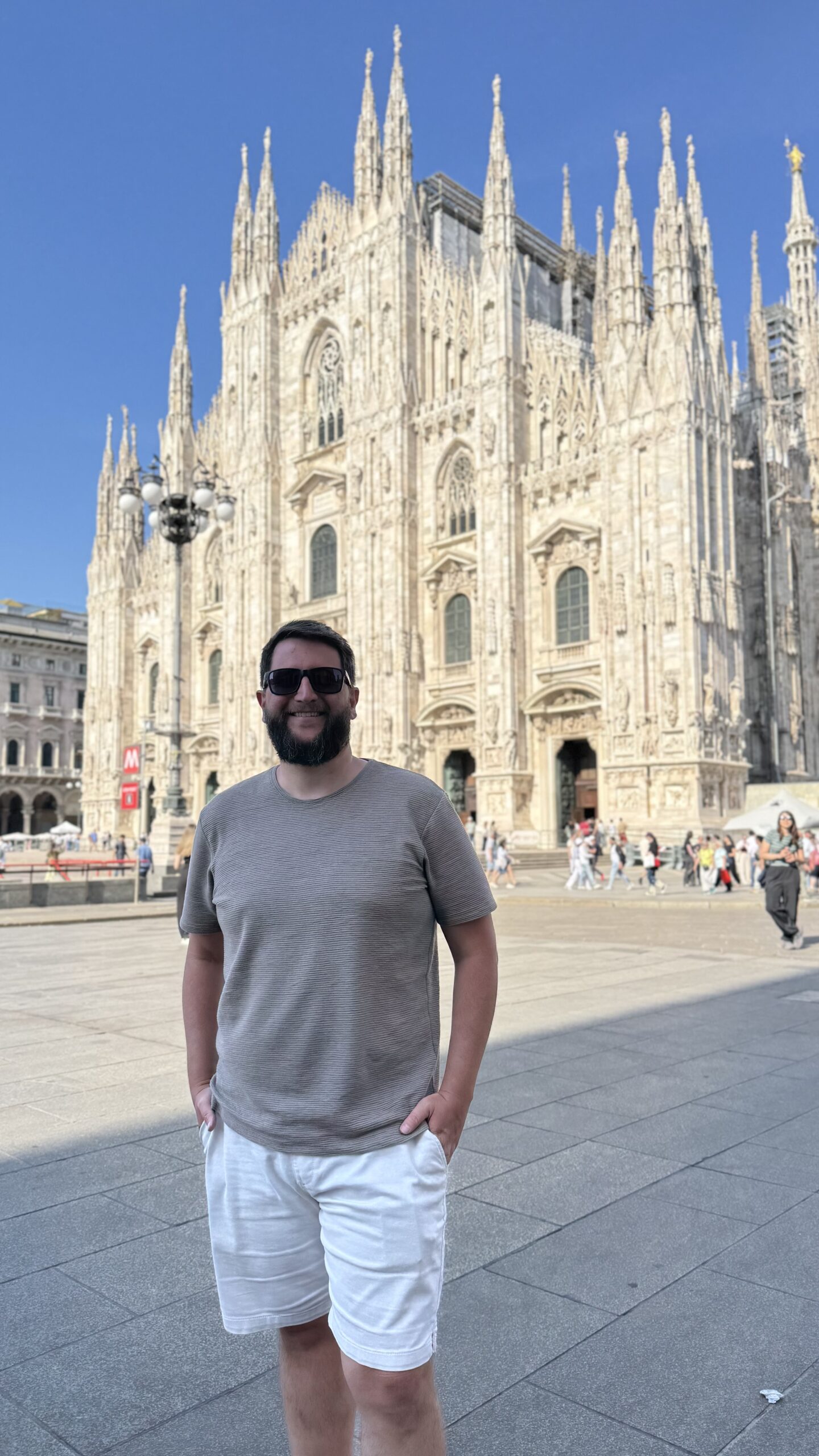Homem em frente ao Duomo de Milão, na Praça do Duomo